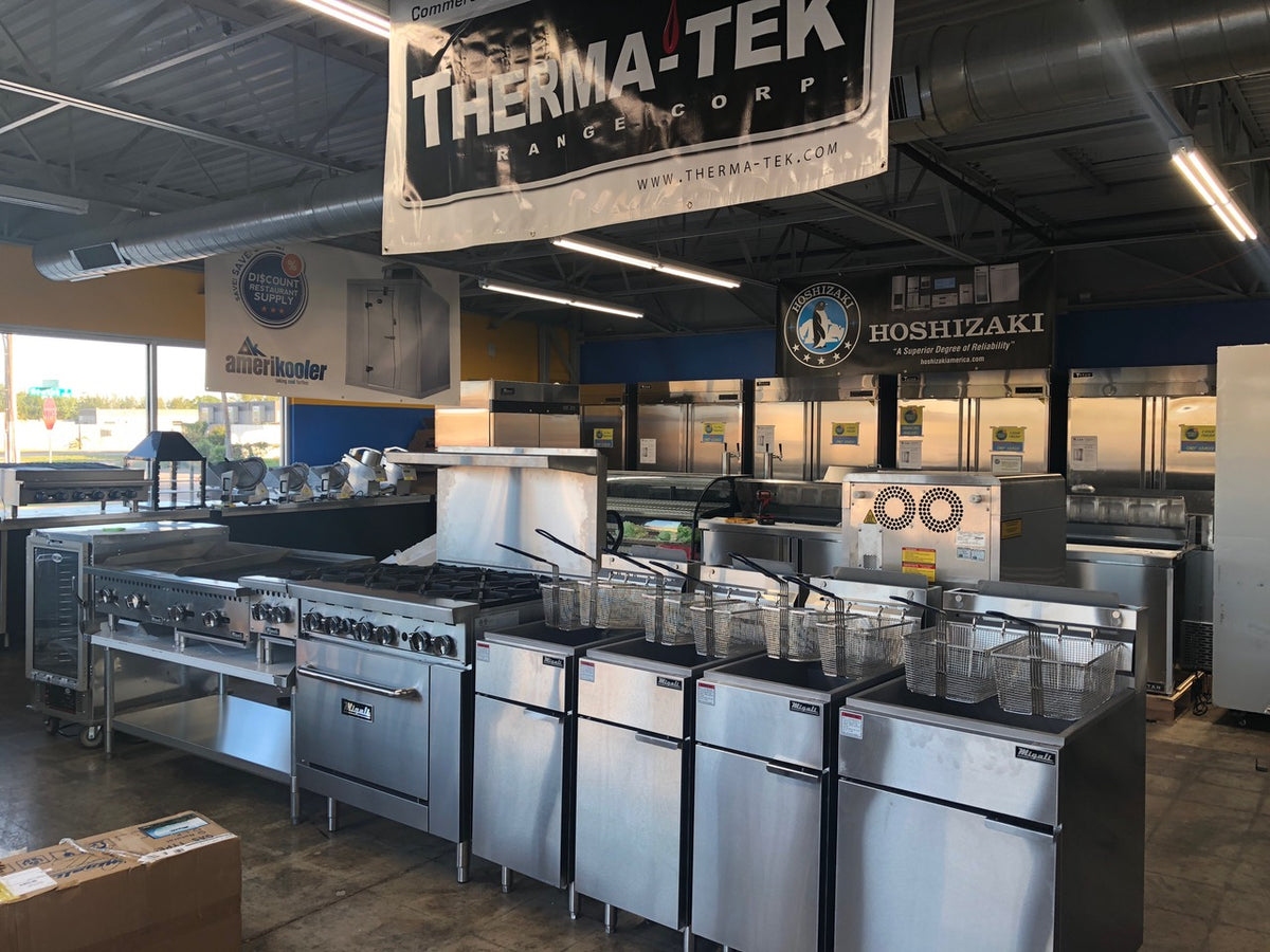 Commercial cooking line with ranges and fryers under manufacturer signage