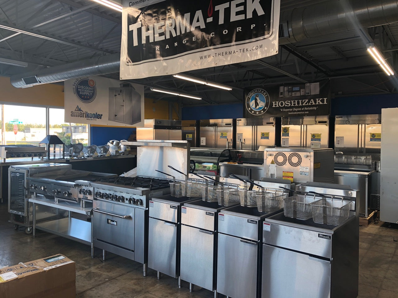 Commercial kitchen equipment staged on a warehouse floor